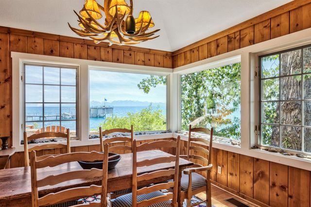 a view of a dining room with furniture large windows and wooden floor