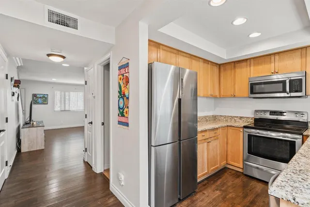 a kitchen with stainless steel appliances granite countertop a refrigerator stove and oven