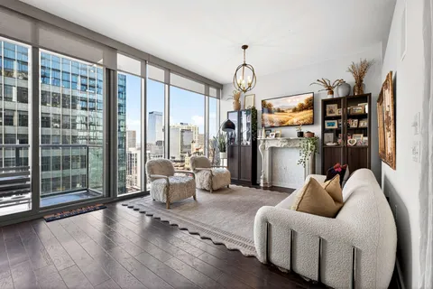 a living room with furniture a ceiling fan and a flat screen tv