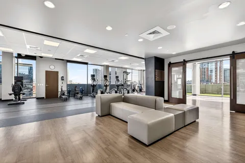 a view of an empty room with wooden floor and windows