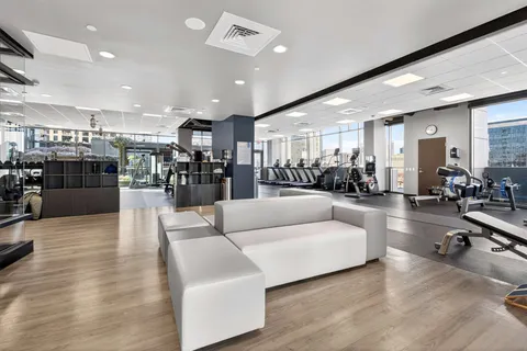 a living room with furniture kitchen view and a wooden floor
