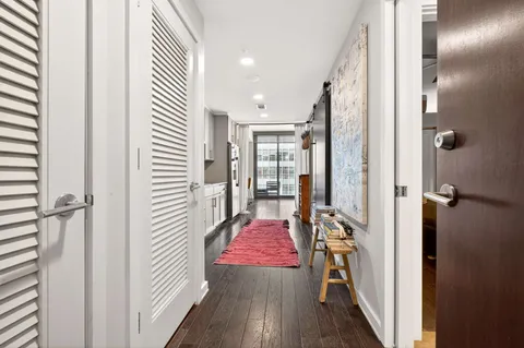 a view of a hallway with wooden floor and staircase