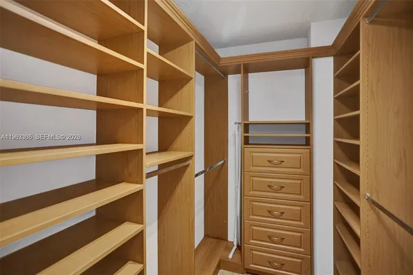 a view of walk in closet with empty racks