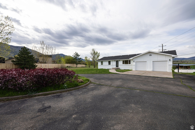 4155 Johnson Road Nibley, UT 84321 - Photo 53 of 71 Ranch-style house featuring driveway, a mountain view, and a garage