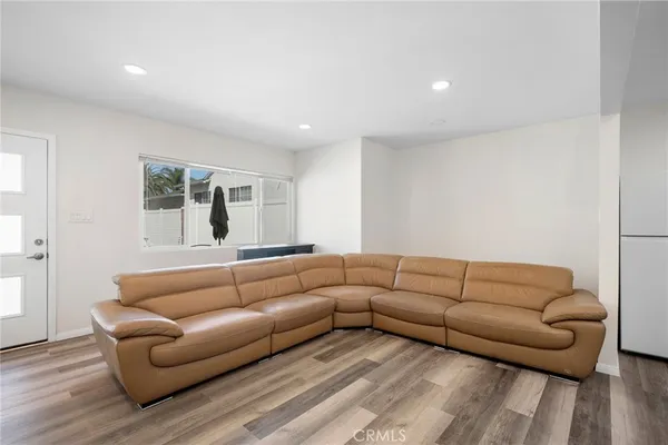 a living room with furniture white walls and wooden floor