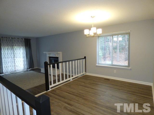 5857 Branchwood Road Raleigh, NC 27609 - Photo 1 of 42 an empty room with wooden floor fan and windows