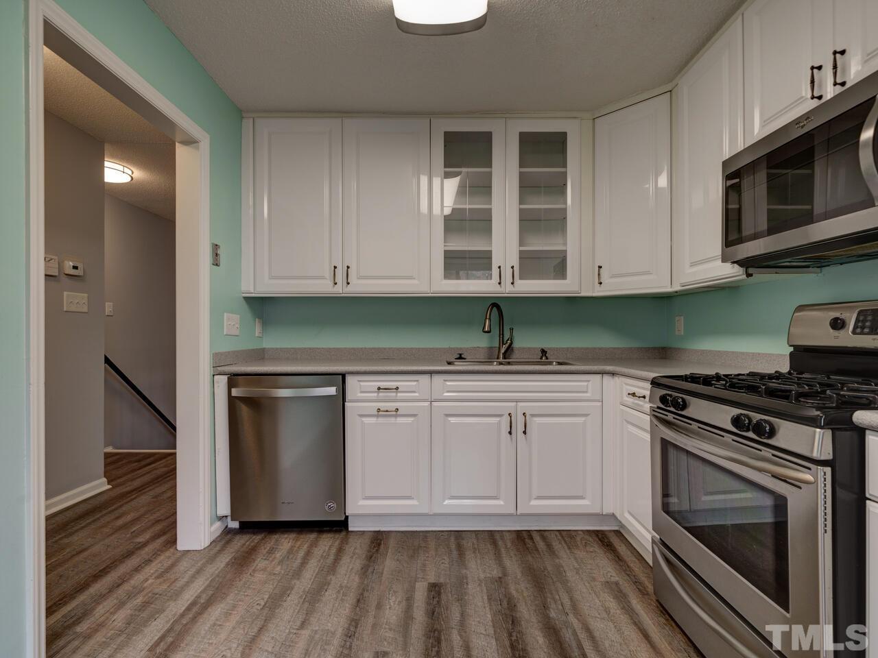 5857 Branchwood Road Raleigh, NC 27609 - Photo 15 of 42 a kitchen with granite countertop wooden cabinets stainless steel appliances and a sink