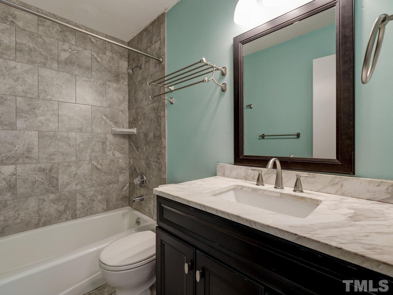 5857 Branchwood Road Raleigh, NC 27609 - Photo 26 of 42 a bathroom with a granite countertop bathtub sink vanity mirror and toilet