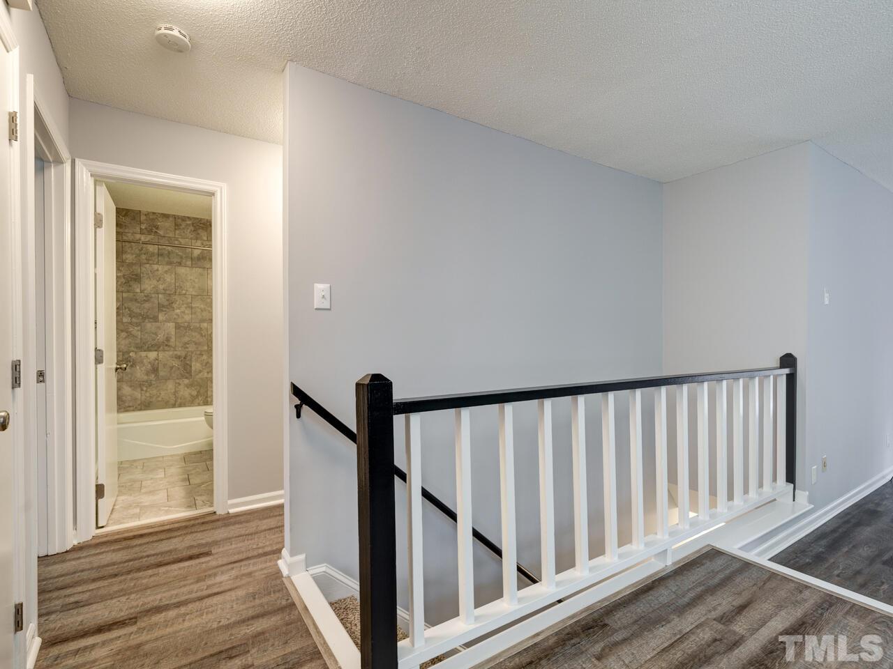 5857 Branchwood Road Raleigh, NC 27609 - Photo 27 of 42 a view of a hallway with wooden floor and staircase
