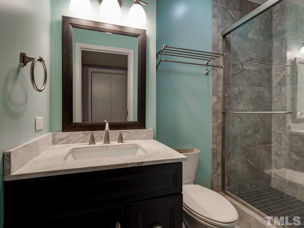 5857 Branchwood Road Raleigh, NC 27609 - Photo 32 of 42 a bathroom with a sink a toilet and shower