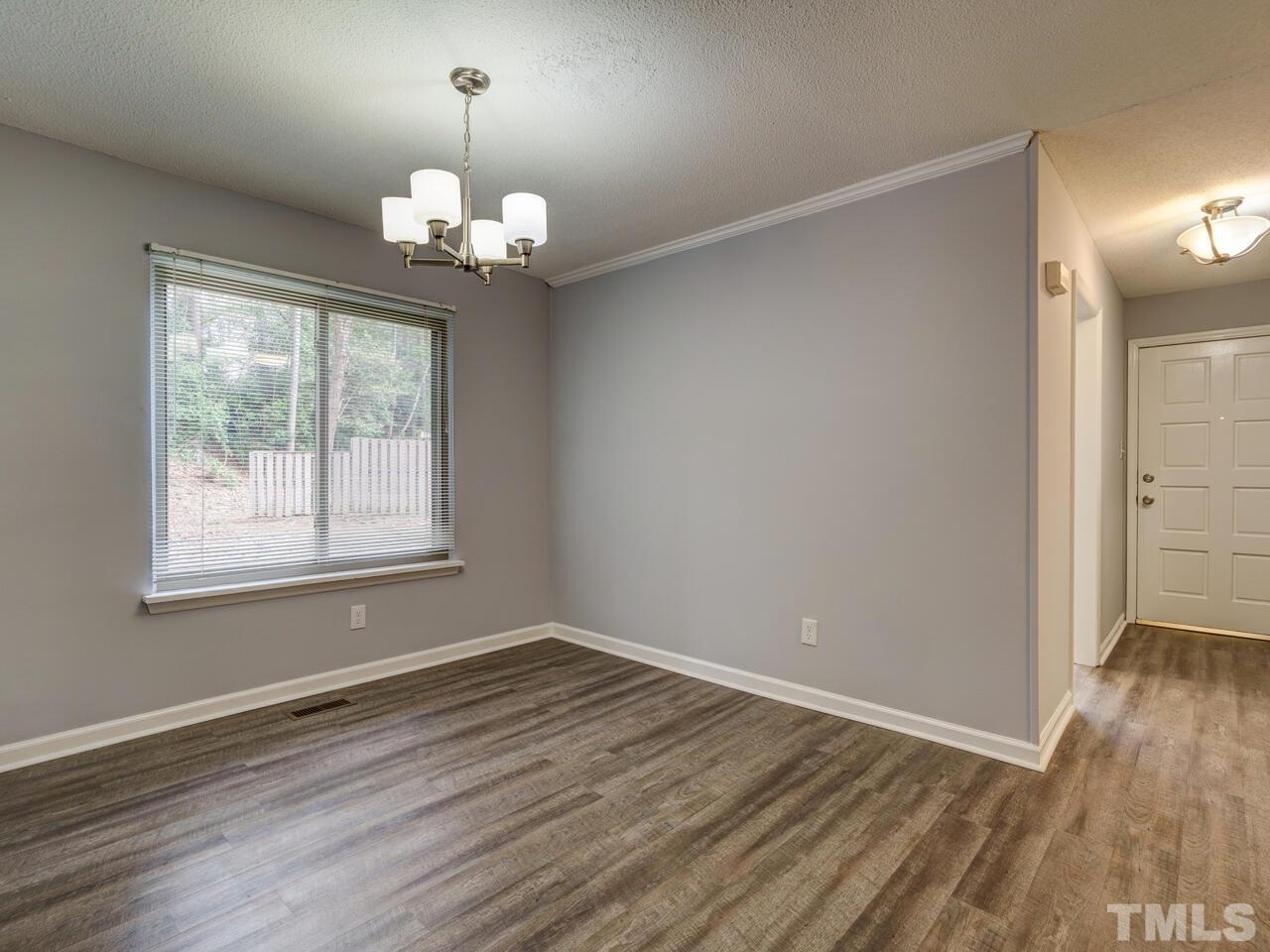 5857 Branchwood Road Raleigh, NC 27609 - Photo 9 of 42 wooden floor in an empty room with a window