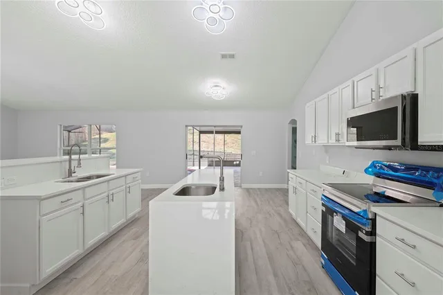 a kitchen with a stove a sink and a microwave