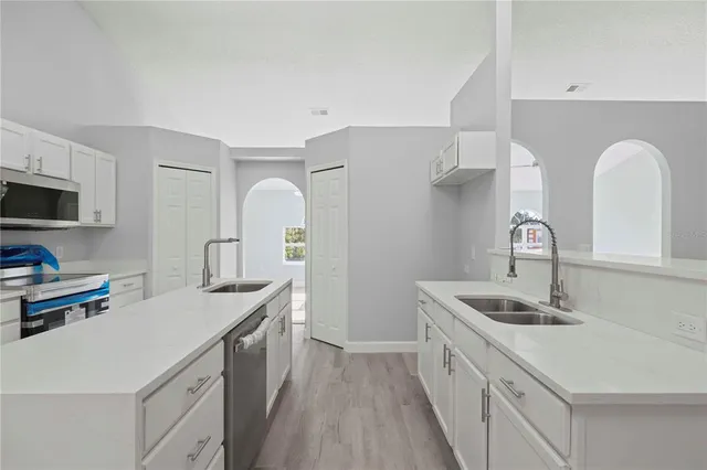 a kitchen with a sink cabinets and appliances
