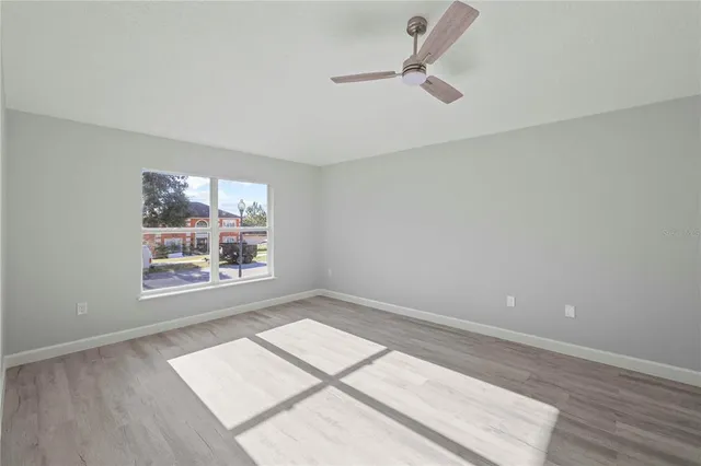 an empty room with a window and wooden floor