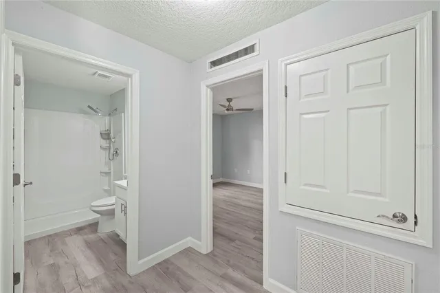 an empty room with windows and fan