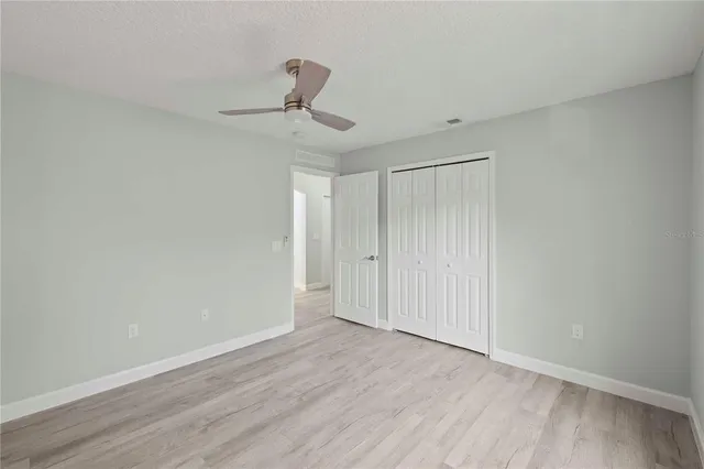 a view of a hallway with wooden floor and a chandelier