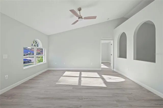 a view of a house with a yard and a large tree