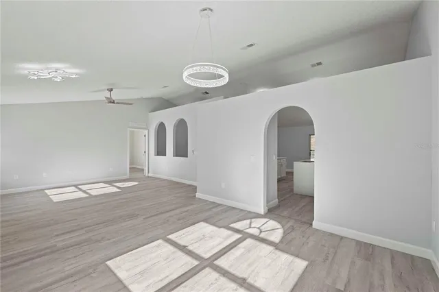 a view of a room with wooden floor and ceiling fan