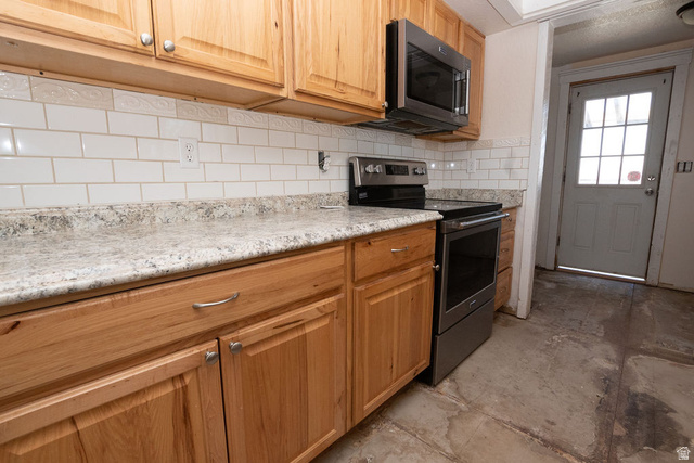 570 West Main Street Beaver, UT 84713 - Photo 10 of 43 Kitchen featuring light wood cabinetry, stone-finish countertops, and a subway tile backsplash