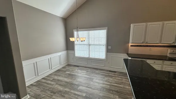 a kitchen with granite countertop white cabinets and window