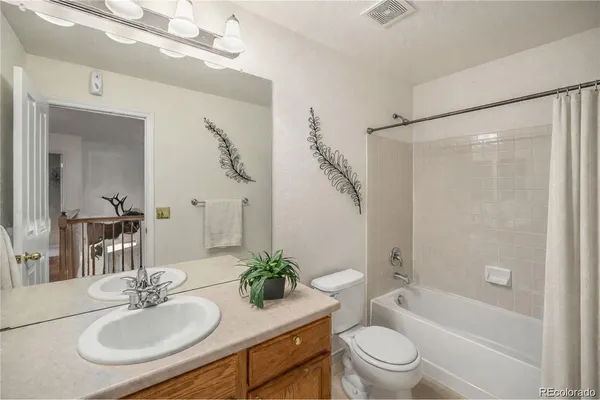 a bathroom with a granite countertop sink toilet a mirror a shower and a bathtub