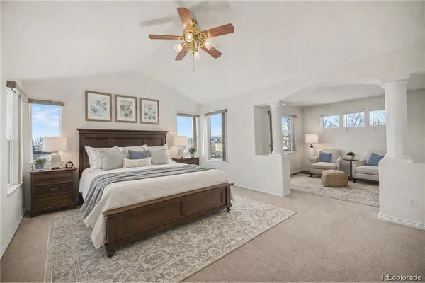 a spacious bedroom with a bed a couch and a chandelier