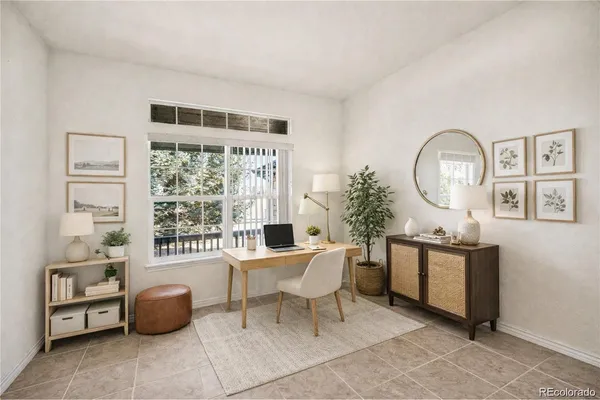 a living room with furniture a window and a potted plant