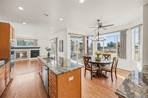 a dining hall with stainless steel appliances granite countertop a stove and a refrigerator