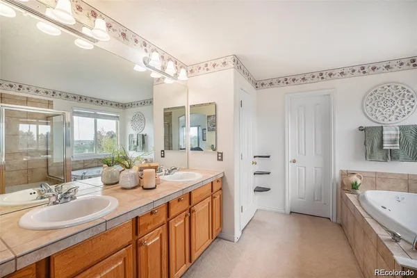 a spacious bathroom with a double vanity sink mirror and bathtub