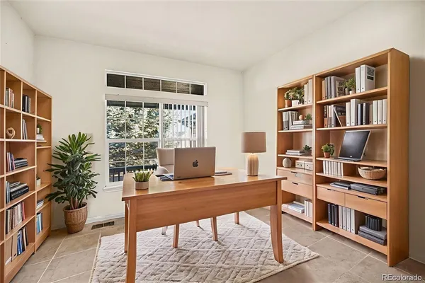a view of a workspace with furniture and a book shelf