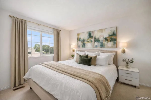 a bedroom with a bed and a painting on the wall