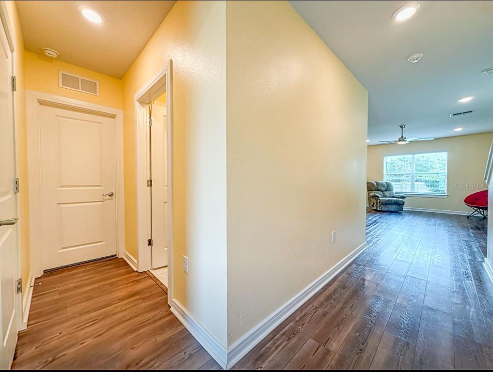 9324 Rally Spring Loop Wesley Chapel, FL 33545 - Photo 11 of 57 a view of a hallway with wooden floor and furniture