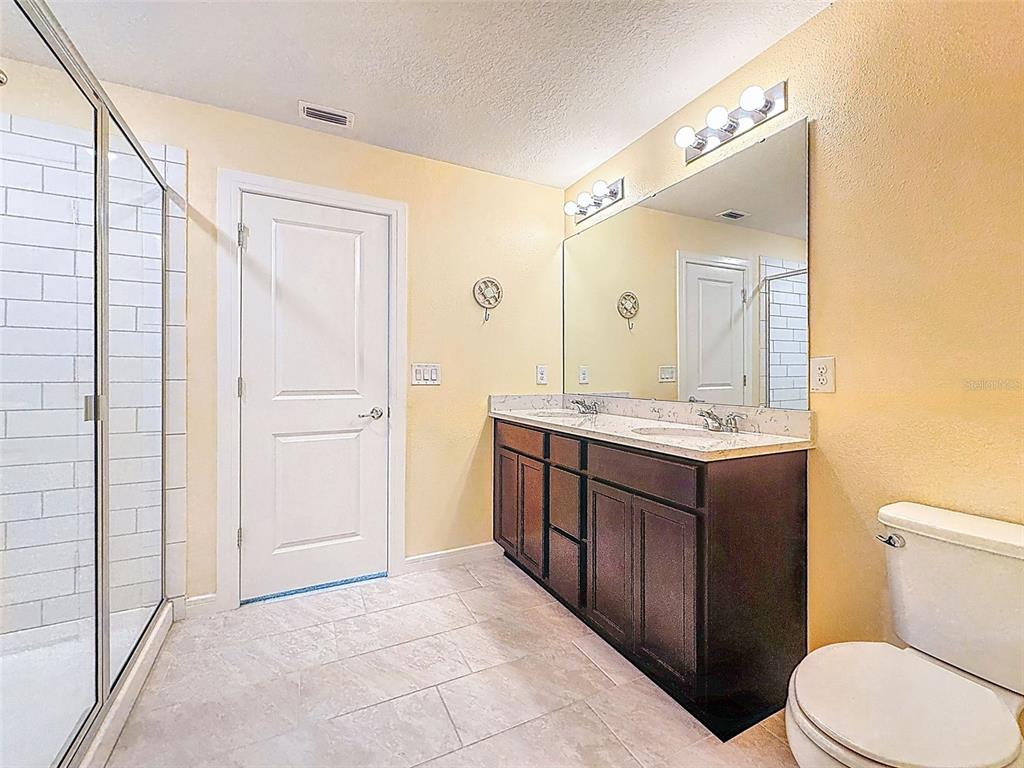 9324 Rally Spring Loop Wesley Chapel, FL 33545 - Photo 25 of 57 a bathroom with a granite countertop sink toilet and mirror