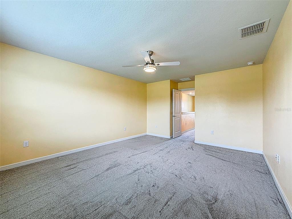 9324 Rally Spring Loop Wesley Chapel, FL 33545 - Photo 27 of 57 an empty room with a empty space and a ceiling fan