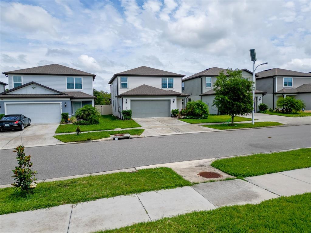 9324 Rally Spring Loop Wesley Chapel, FL 33545 - Photo 3 of 57 a front view of a house with a yard and potted plants