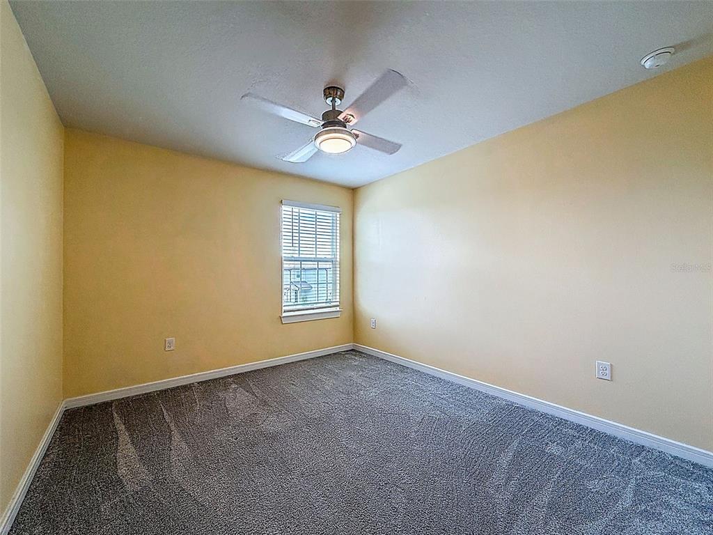 9324 Rally Spring Loop Wesley Chapel, FL 33545 - Photo 38 of 57 an empty room with windows and fan