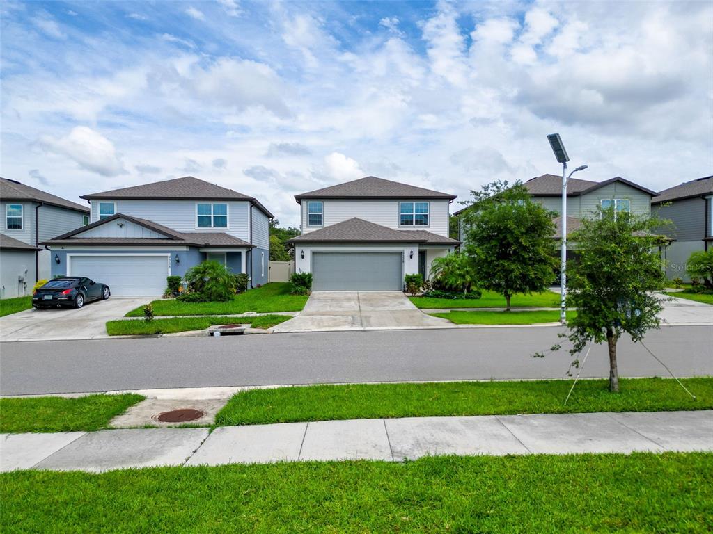 9324 Rally Spring Loop Wesley Chapel, FL 33545 - Photo 4 of 57 a view of a yard in front of a house