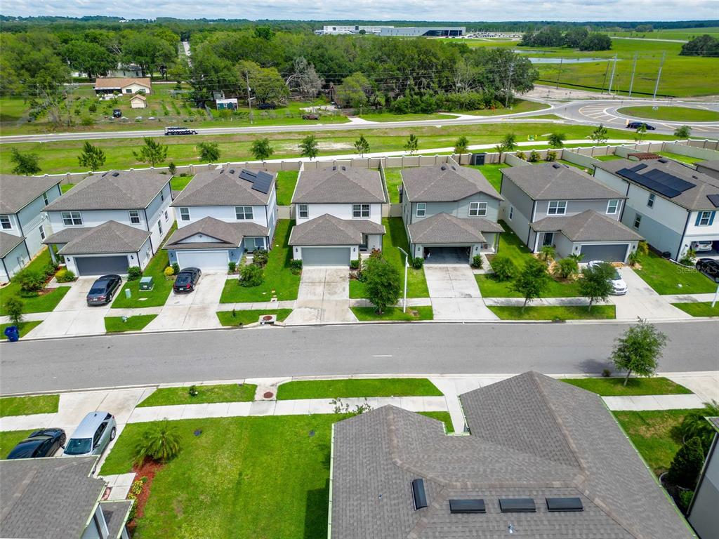 9324 Rally Spring Loop Wesley Chapel, FL 33545 - Photo 47 of 57 an aerial view of a house with a garden and a yard