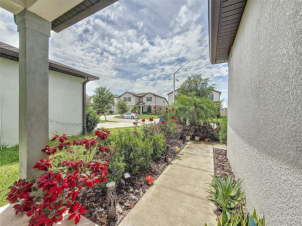 9324 Rally Spring Loop Wesley Chapel, FL 33545 - Photo 5 of 57 a front view of a house with a yard and flowers