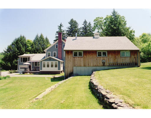 409 Pepperell Road Groton, MA 01450 - Photo 4 of 28 a white house with a large pool and lawn chairs with wooden fence