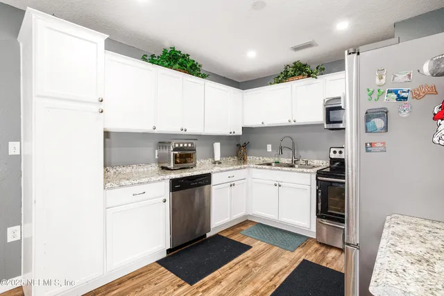 a kitchen with granite countertop stainless steel appliances a sink and counter space