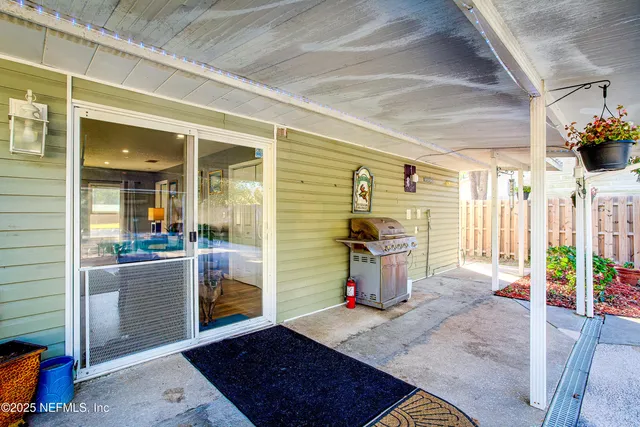 a view of a porch with a table and chairs and potted plants
