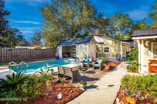 a view of a patio with table and chairs potted plants with wooden fence