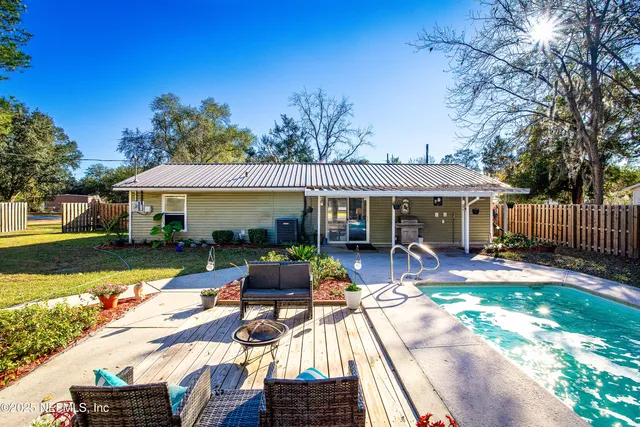a view of a patio with table and chairs potted plants and large tree