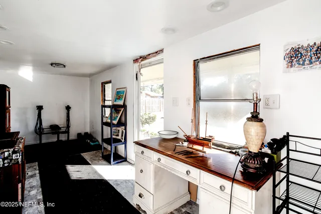 a living room with stainless steel appliances kitchen island granite countertop furniture a rug and a large window
