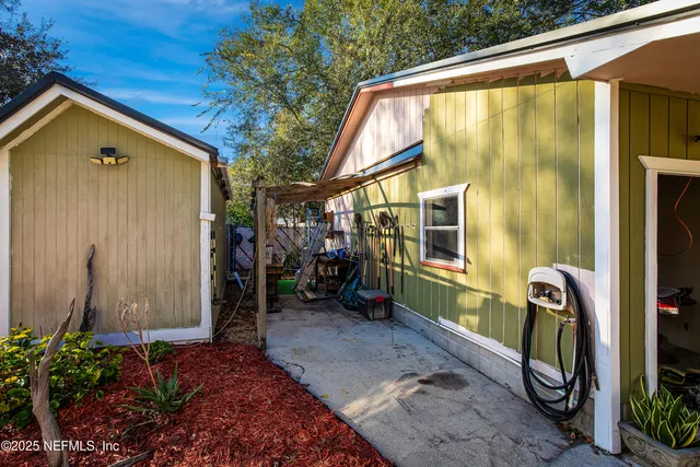 a view of a house with a large window and potted plants