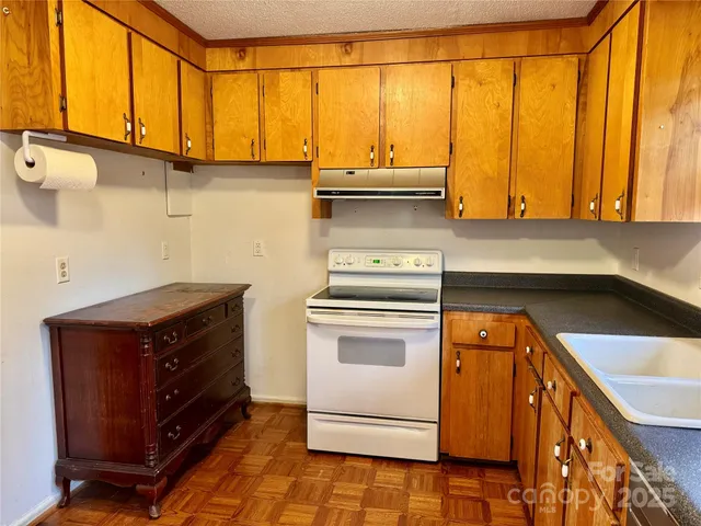 a kitchen with stainless steel appliances cabinets and wooden floor