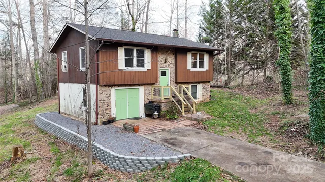a view of a house with a yard and large tree