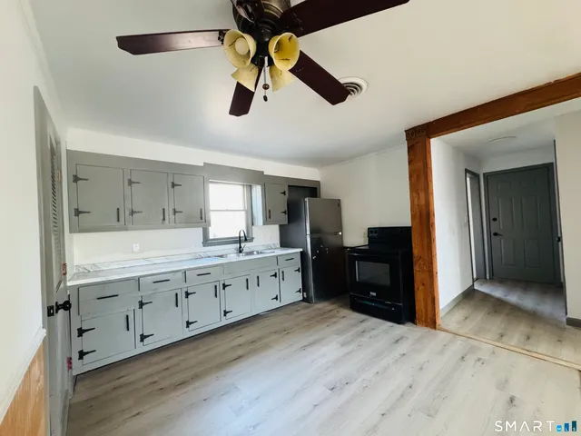 a kitchen with granite countertop white cabinets and stainless steel appliances
