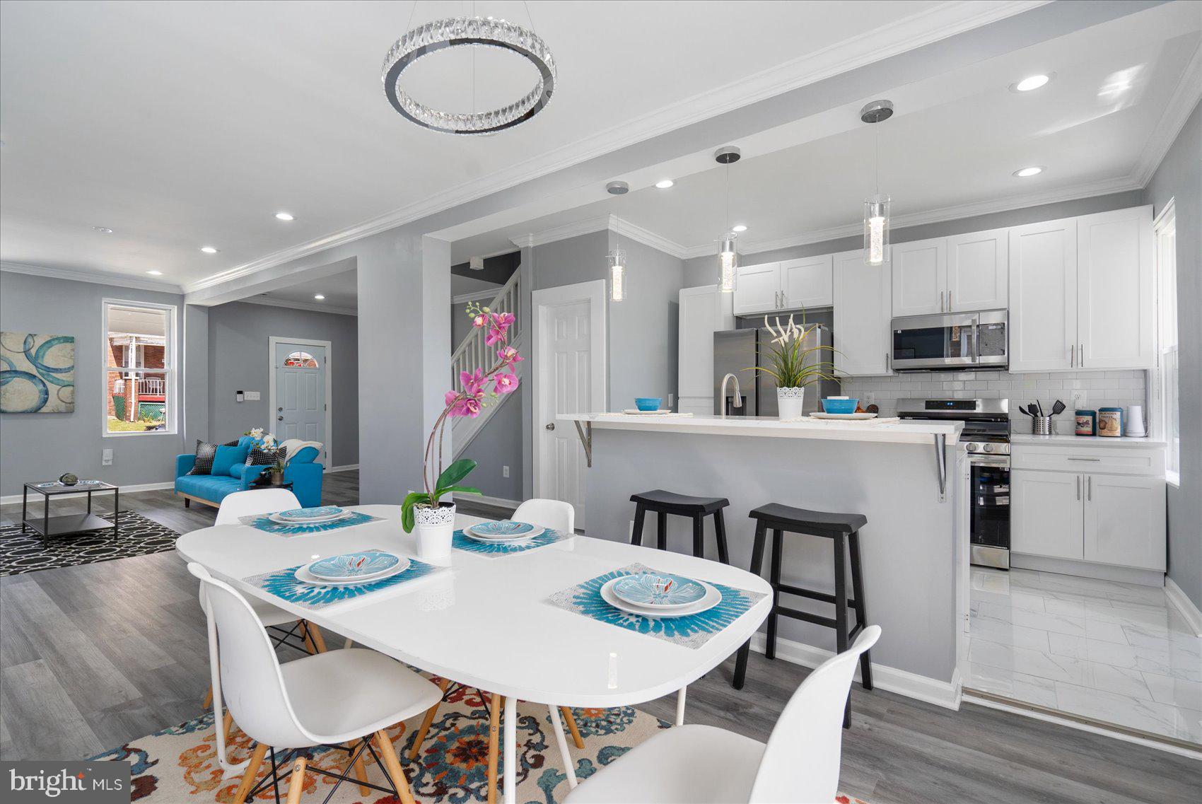 a kitchen with stainless steel appliances granite countertop a dining table chairs and view living room